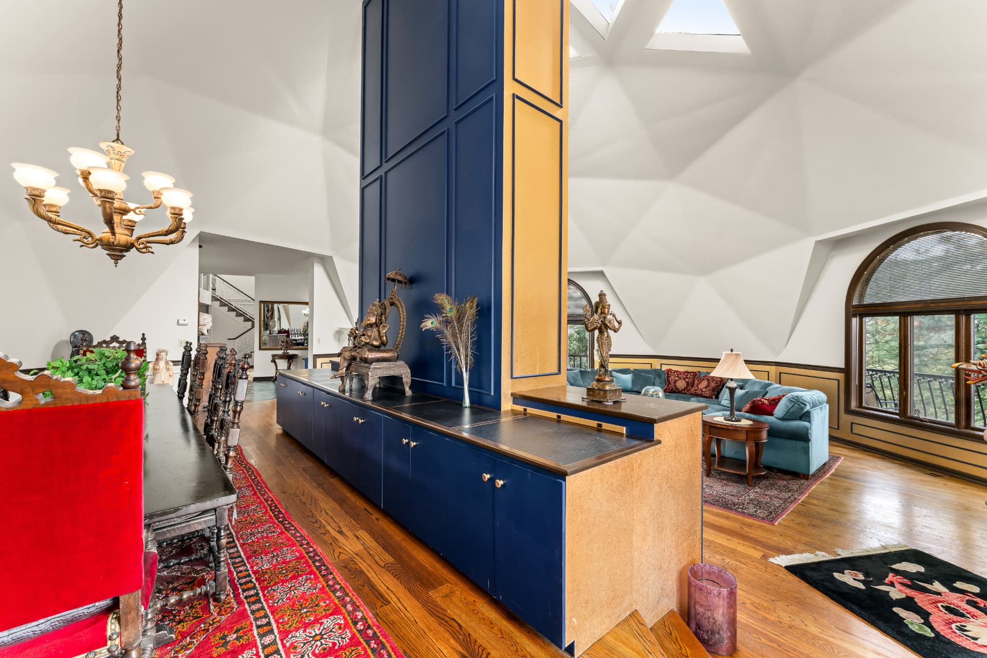 Dining and living areas divided by the blue-and-gold central hearth