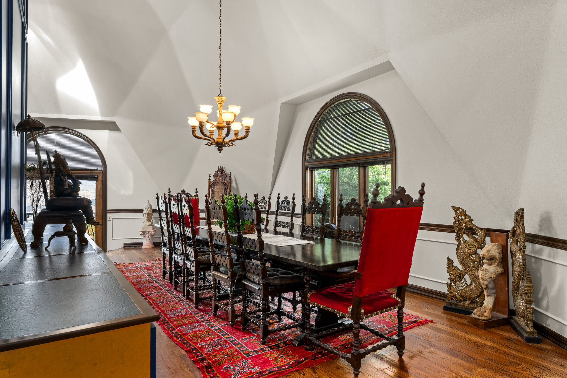Formal dining room beneath the faceted ceiling with arched windows and seating for a large gathering