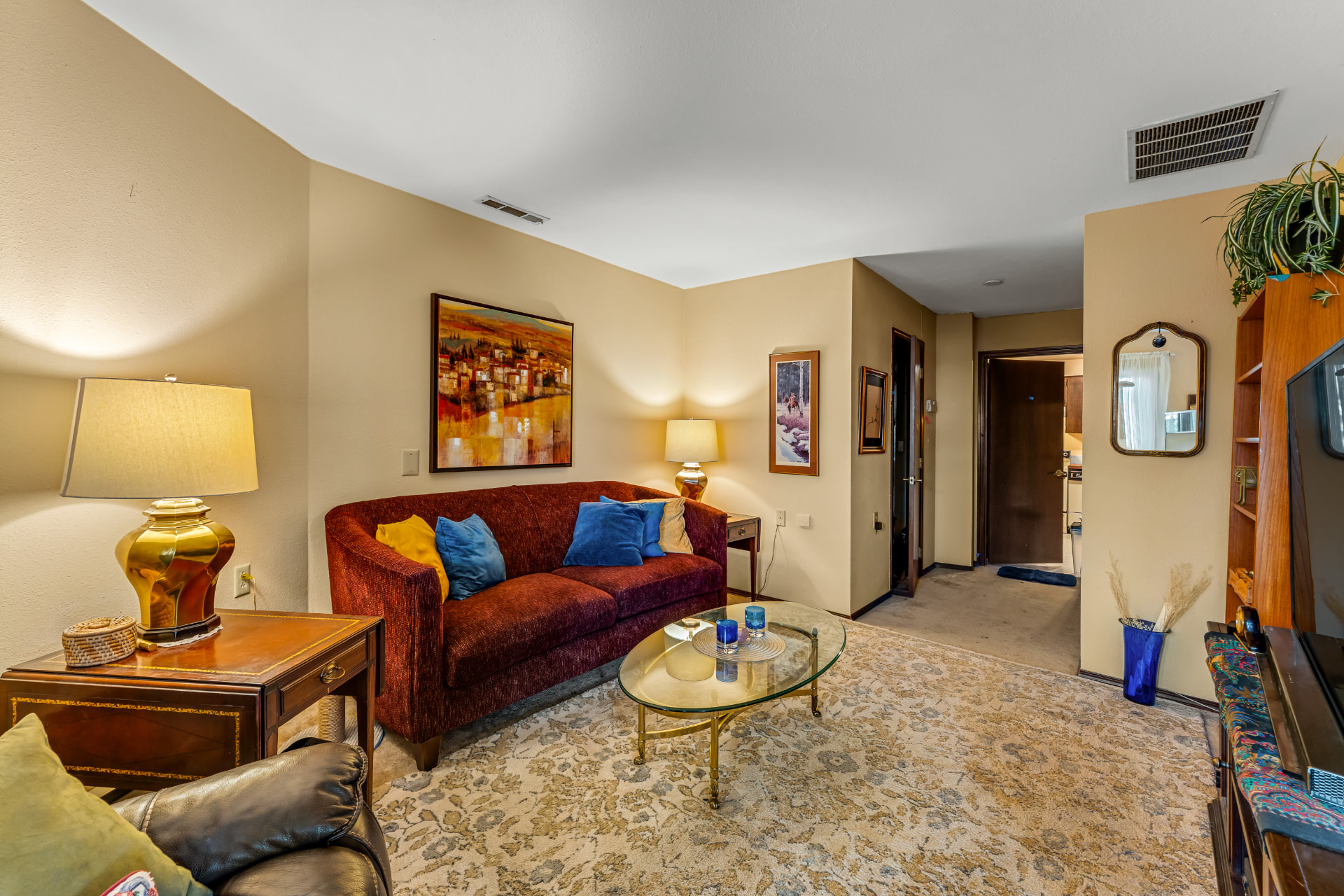 Sitting room in the self-contained multi-generational suite, with a sofa, media area, and adjacent rooms