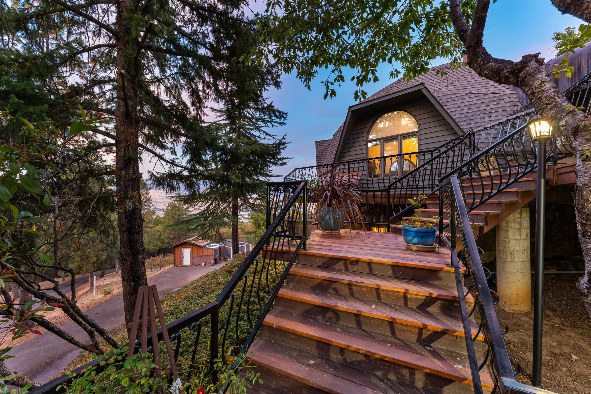 Illuminated deck stairs and arched windows at twilight