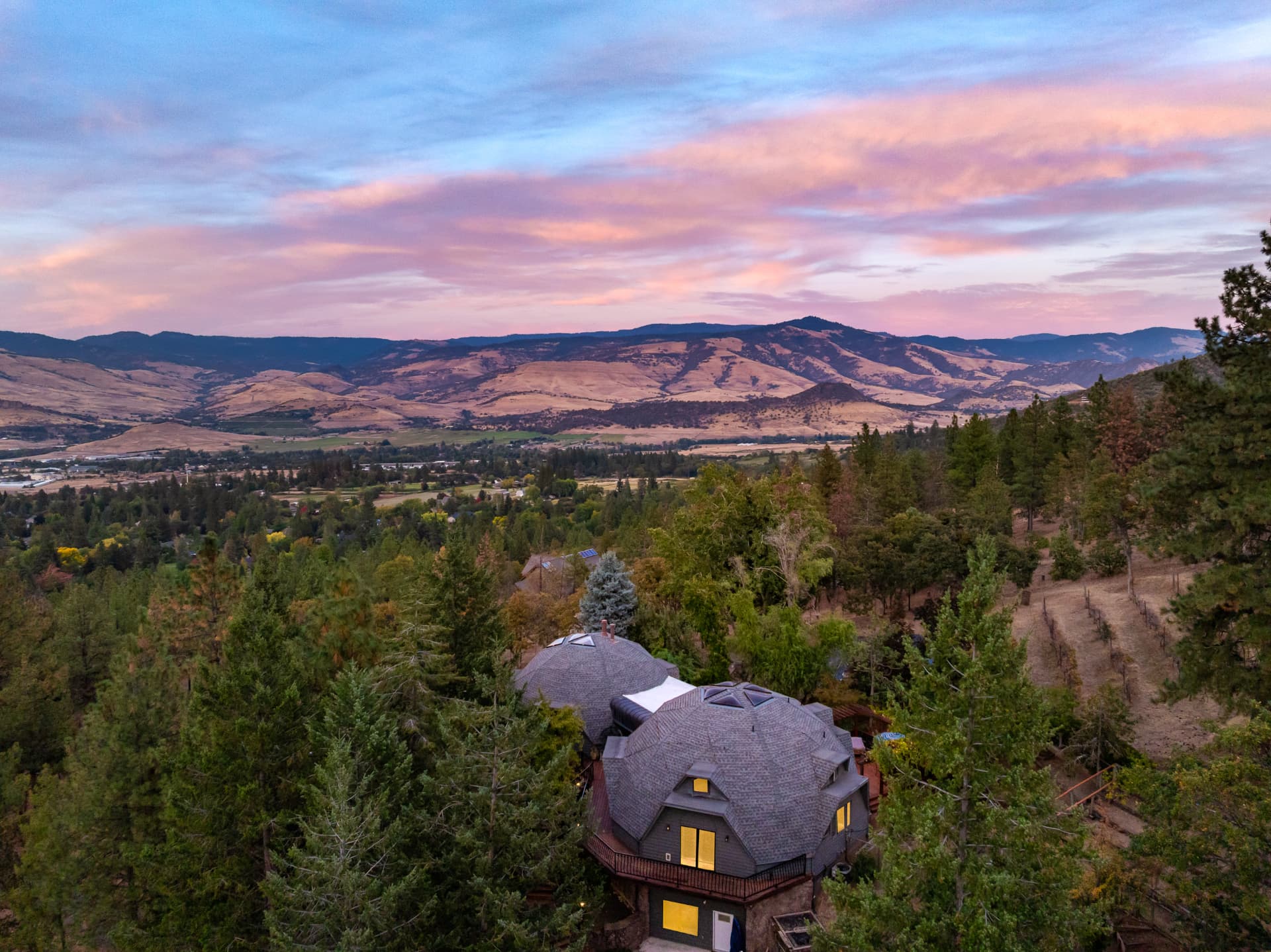 Aerial twilight view of the connected domes, surrounding hillside, and Rogue Valley
